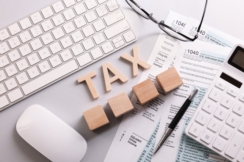 word,tax,,wooden,cubes,,calculator,,keyboard,and,documents,on,light